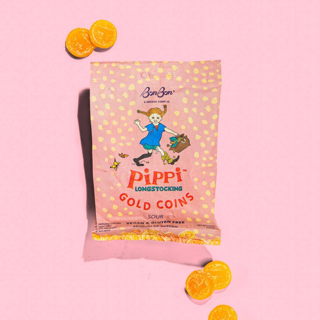 Pink package of Pippi Longstocking Gold Coins on a pink background with orange candy coins.