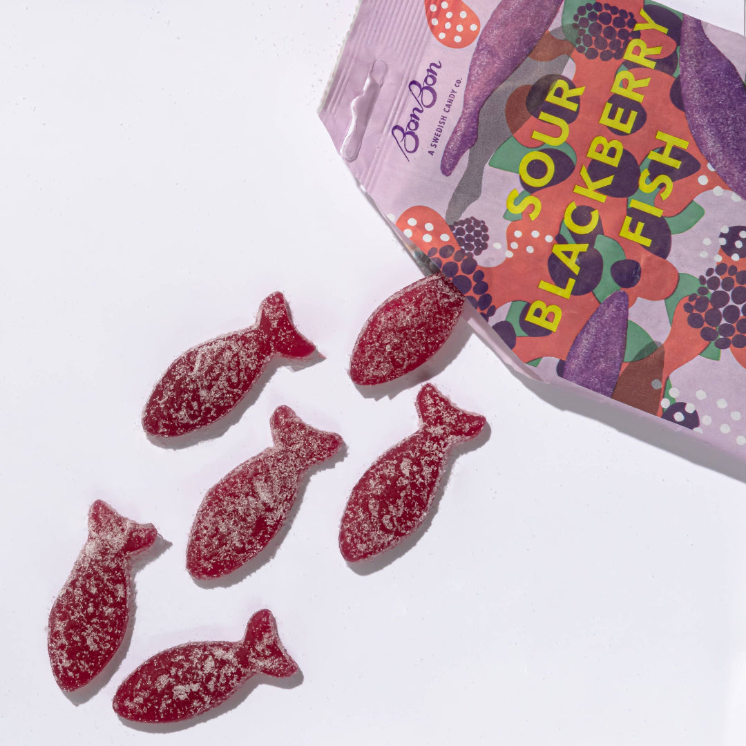 Sour blackberry fish candies with a colorful packaging on a white background