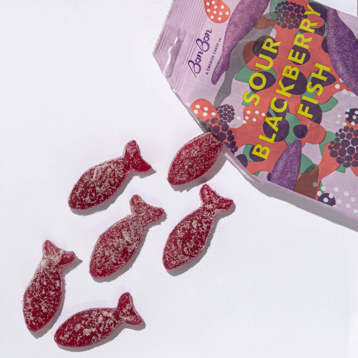 Sour blackberry fish candies with a colorful packaging on a white background