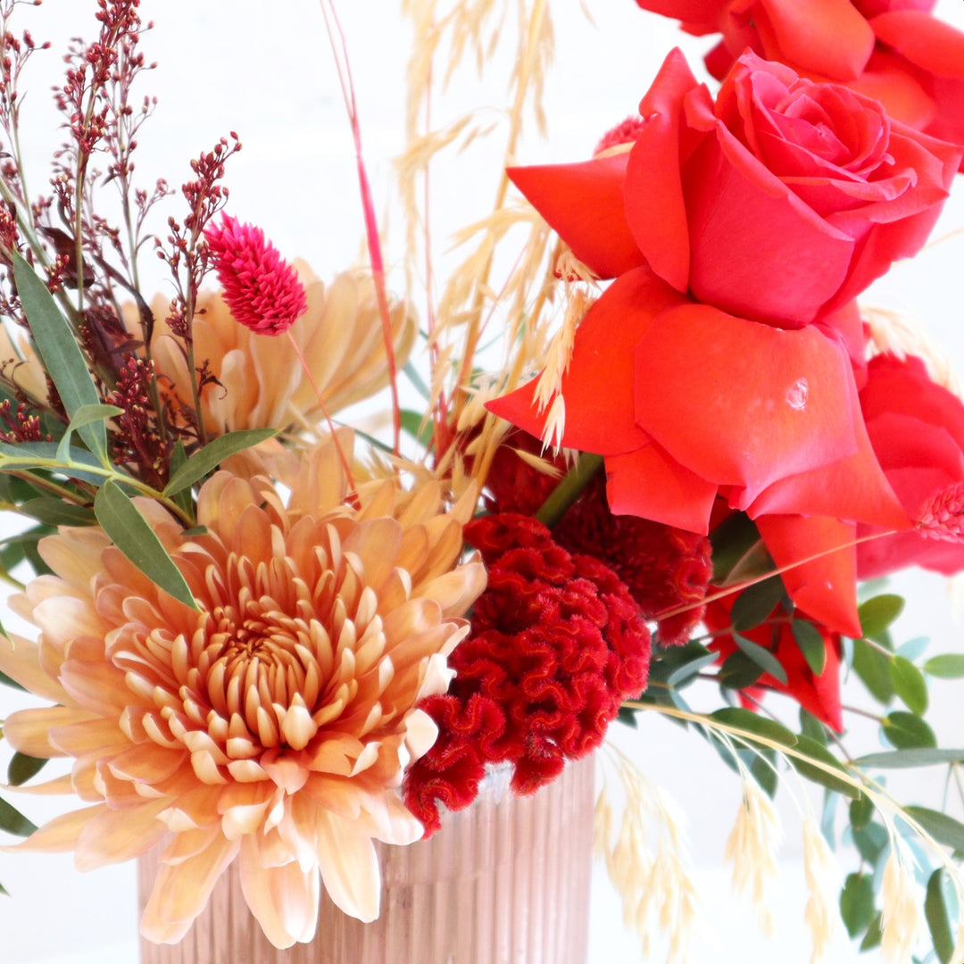 Brilliant | Close up on the celosia argentea, mums, and red roses.