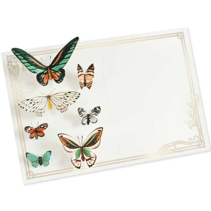 A paper pop up card with paper butterflies, a gold border, and a simple white interior.