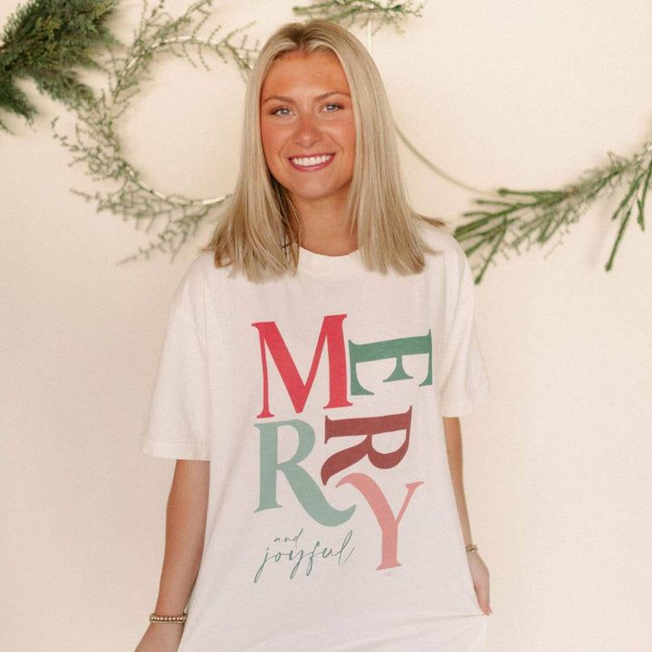 Whitney | Chaudoin Creations | Merry and joyful t-shirt. Comfort colors with colorful text that reads "Merry and Joyful" in a neutral Christmas color palette.