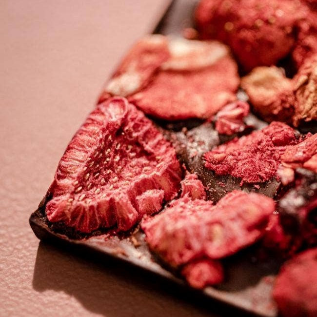 Compartes Chocolate | California Berries Dark Chocolate Bar | Closeup on a dehydrated strawberry.