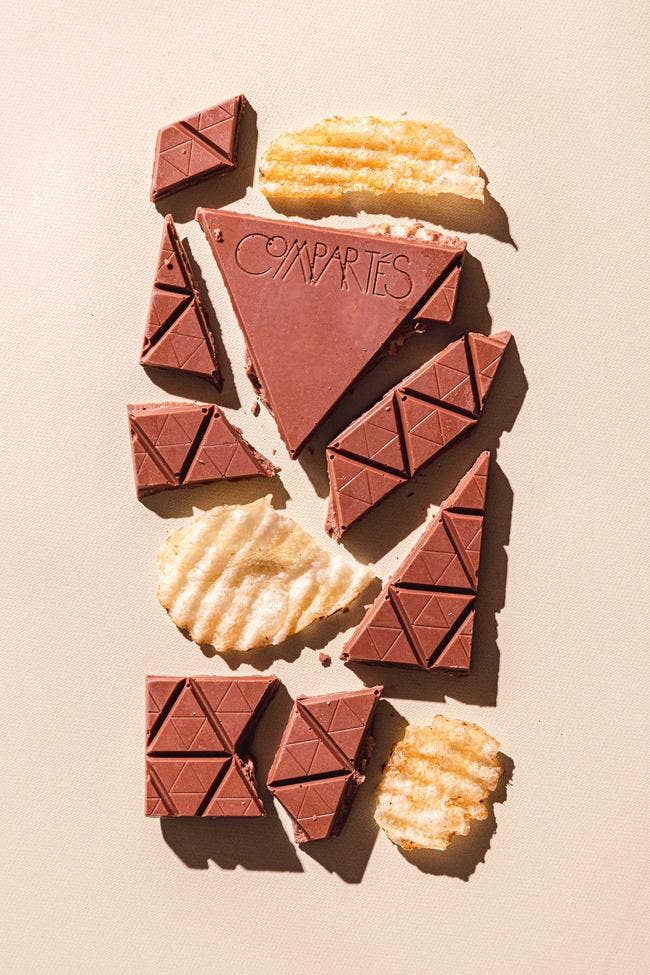 Compartes Chocolates | Potato Chip Crisp | Chocolate with an orange package. Bar broken into pieces.