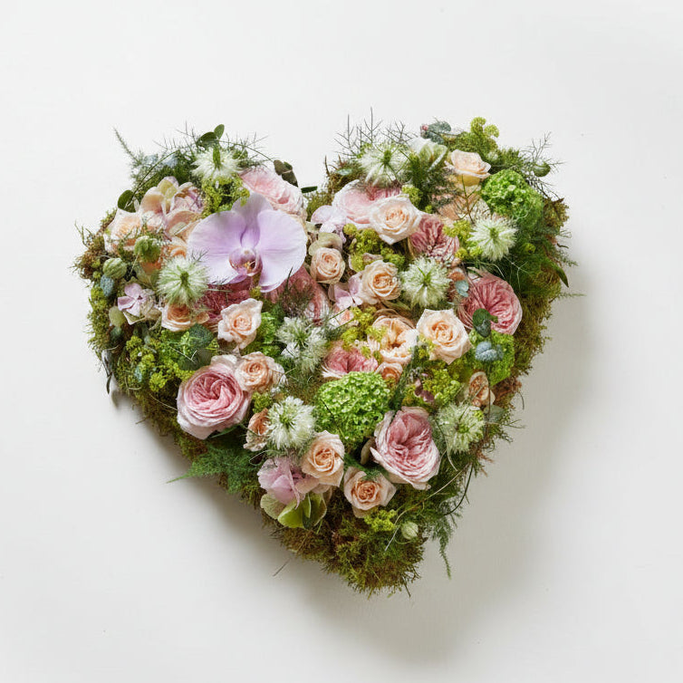 Heart-shaped arrangement of flowers on a stone surface
