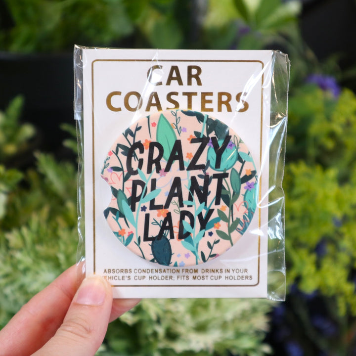 Assorted Car Coasters | Crazy Plant Lady | A light pink plant coaster with illustrated plants overlapping text "Crazy Plant Lady".