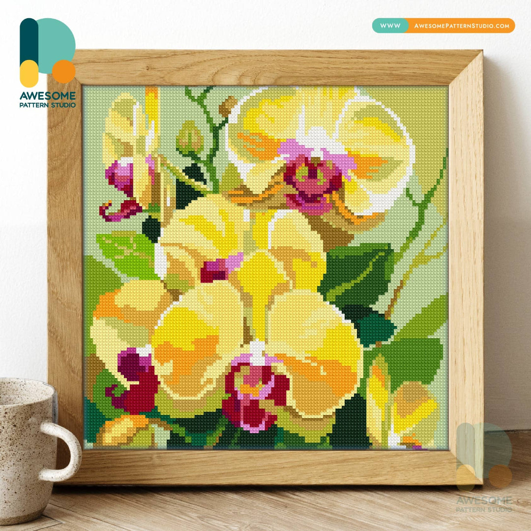 Framed cross-stitched artwork of yellow flowers on a green background, with &