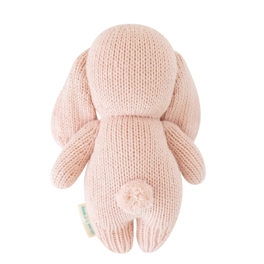 Knitted pink bunny toy on a white background