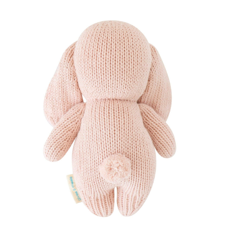 Knitted pink bunny toy on a white background