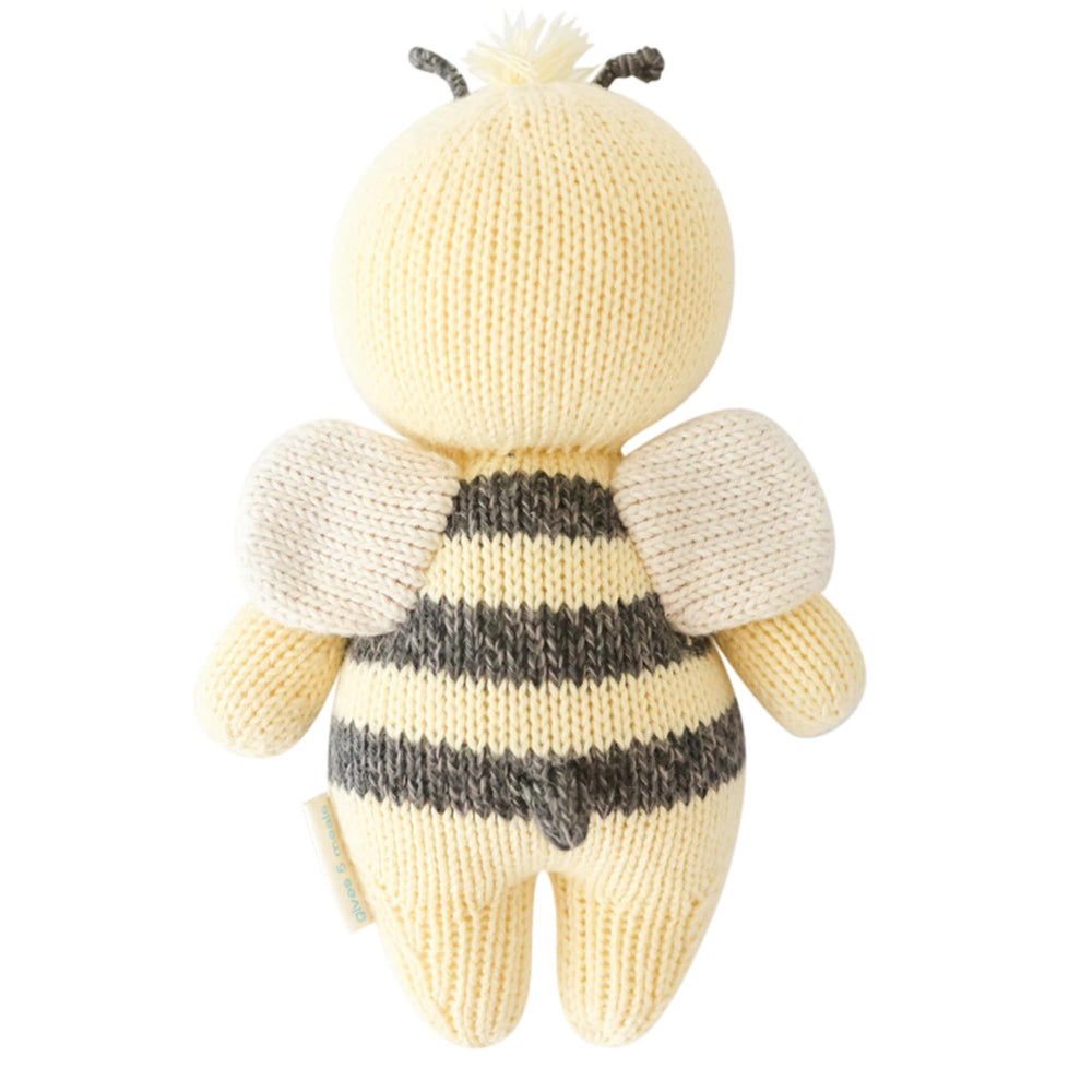 Knitted bee toy with a striped body on a white background