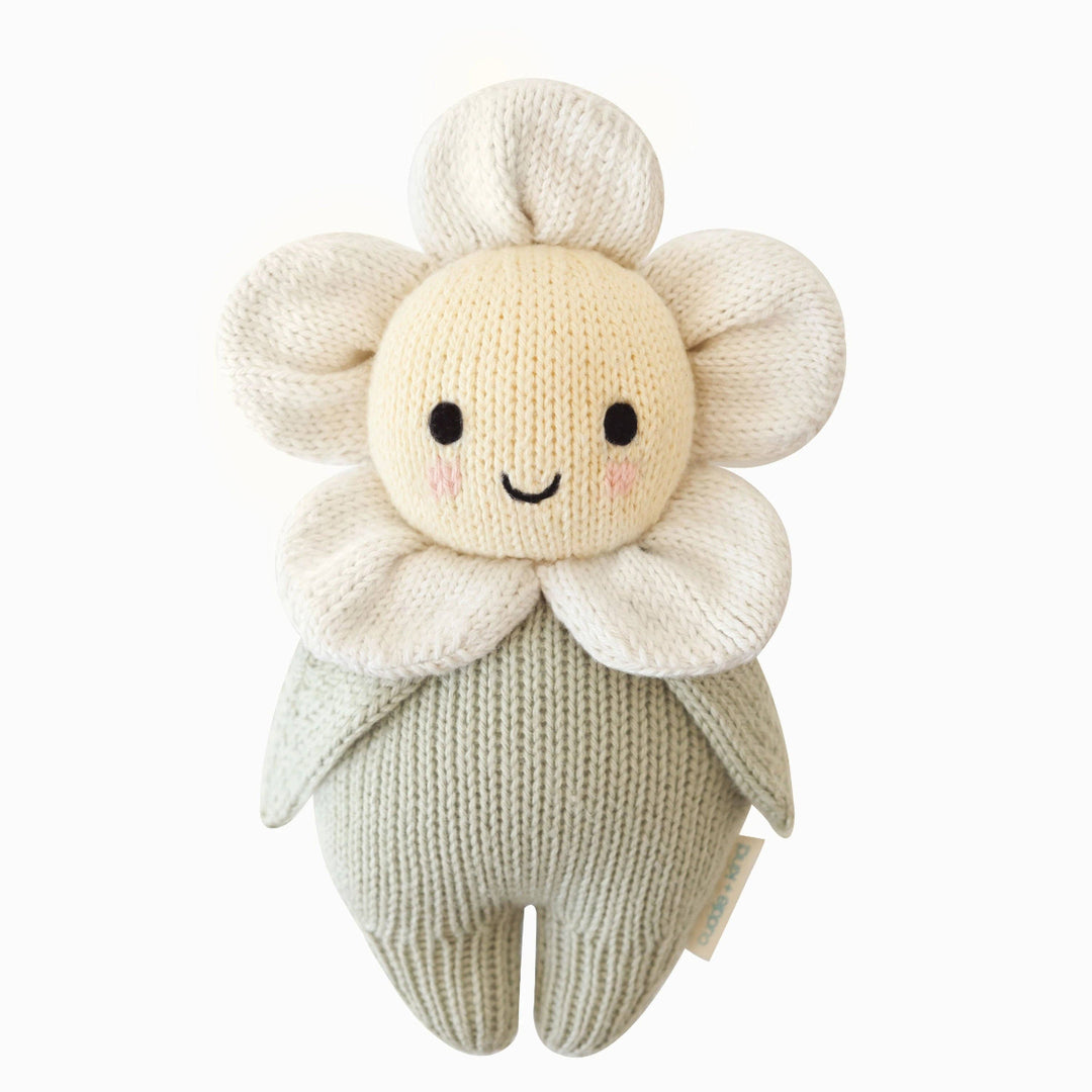 Knitted toy resembling a flower with a smiling face on a white background