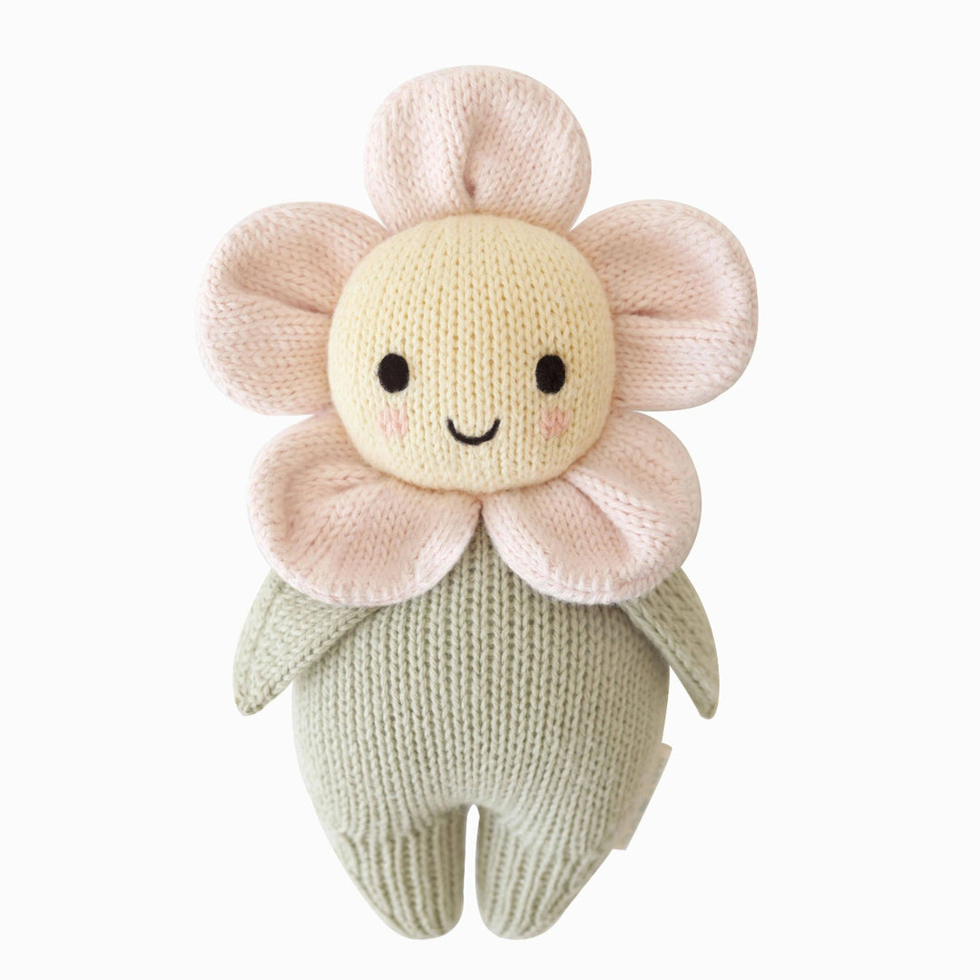 Knitted flower-shaped toy with a smiling face on a white background
