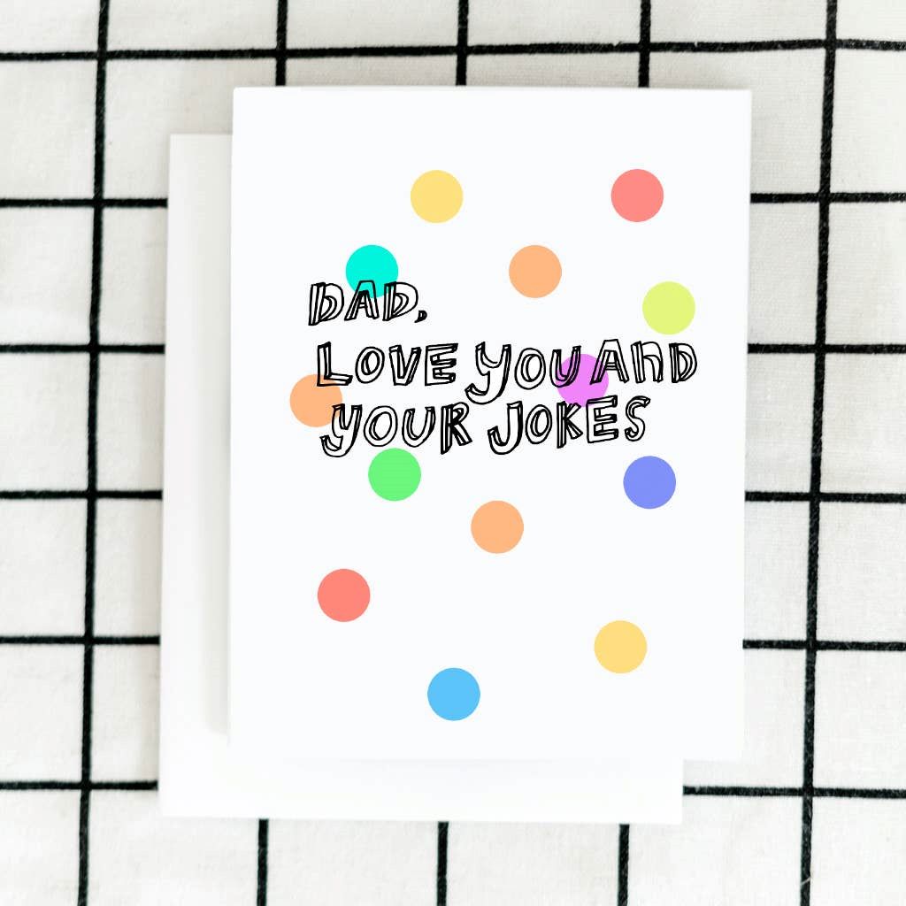 A white card with colorful polka dots and line art text that reads "Dad, love you and your jokes".