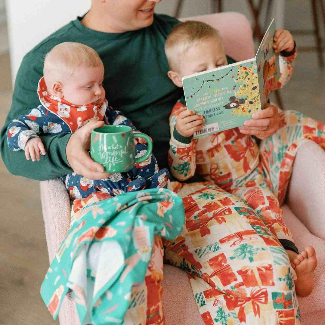 Doe A Deer | Nutcracker | Full Pattern Towel | a mint green towel with a nutcracker figurine pattern. On the lap of a dad and kids with matching pj's reading a book