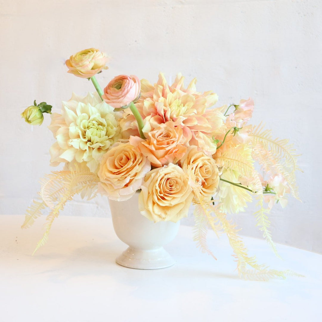 Dreamweaver | Stacy K Floral | A yellow and creamy arrangement with subtle pinks. Some florals pictured are dahlias, ranunculus, roses, and bleached fern.