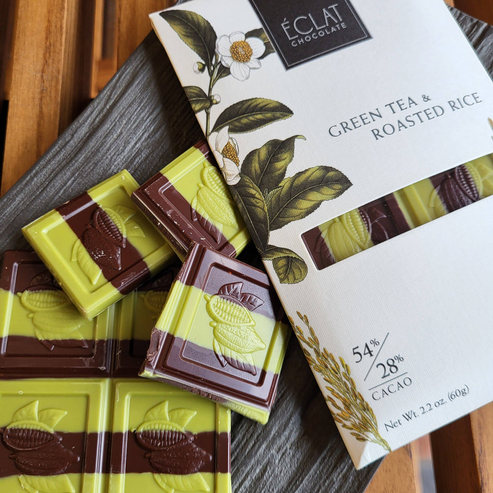 Green tea and roasted rice chocolate bars with packaging on a wooden surface