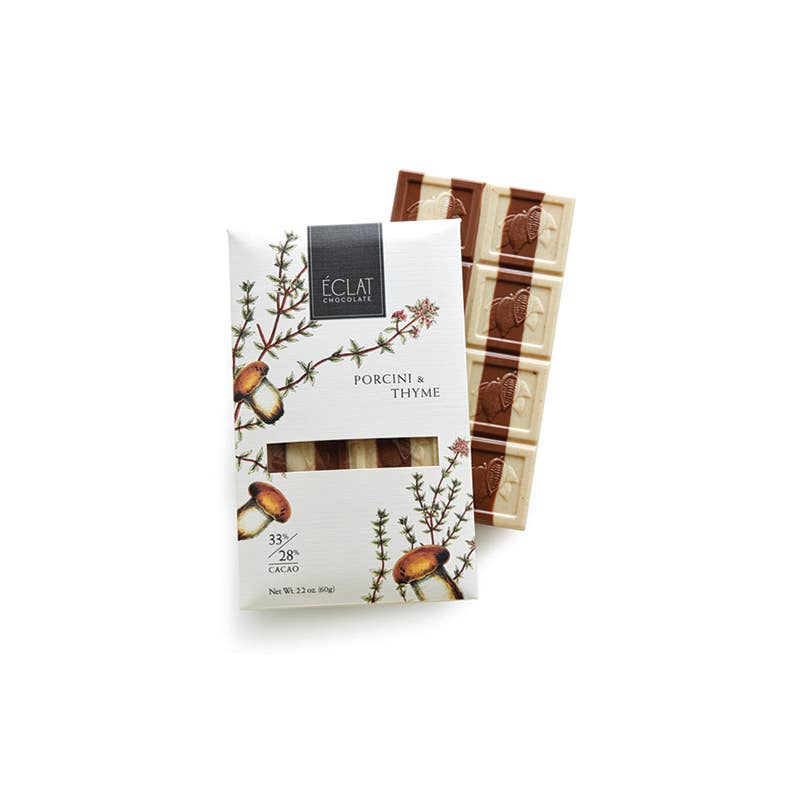 Chocolate bar with packaging featuring porcini mushrooms and thyme on a white background