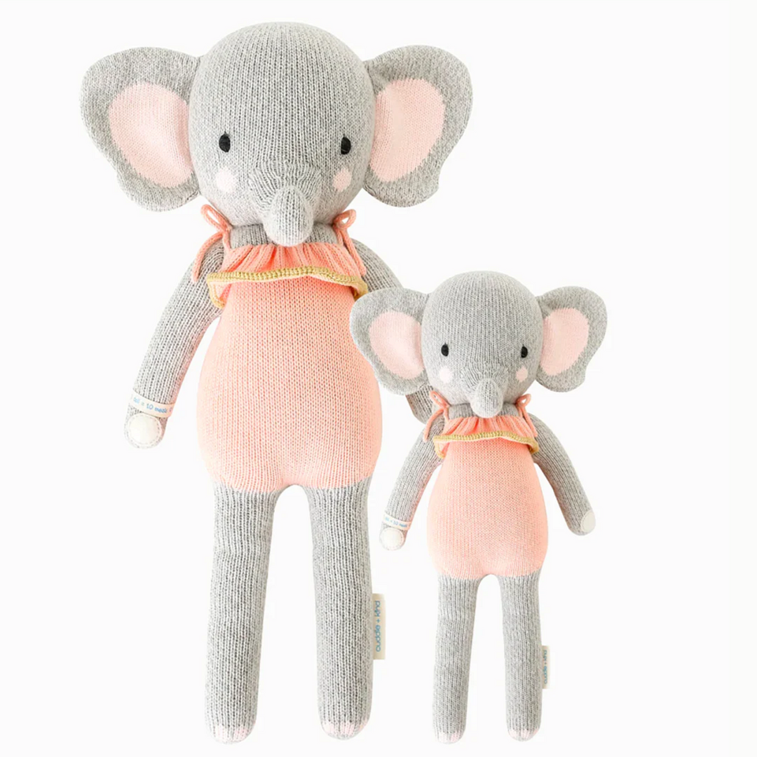 Eloise the Elephant | Cuddle + Kind | A gray elephant with a pink bathing suit with frills. Two sizes pictured, 20" and 13".