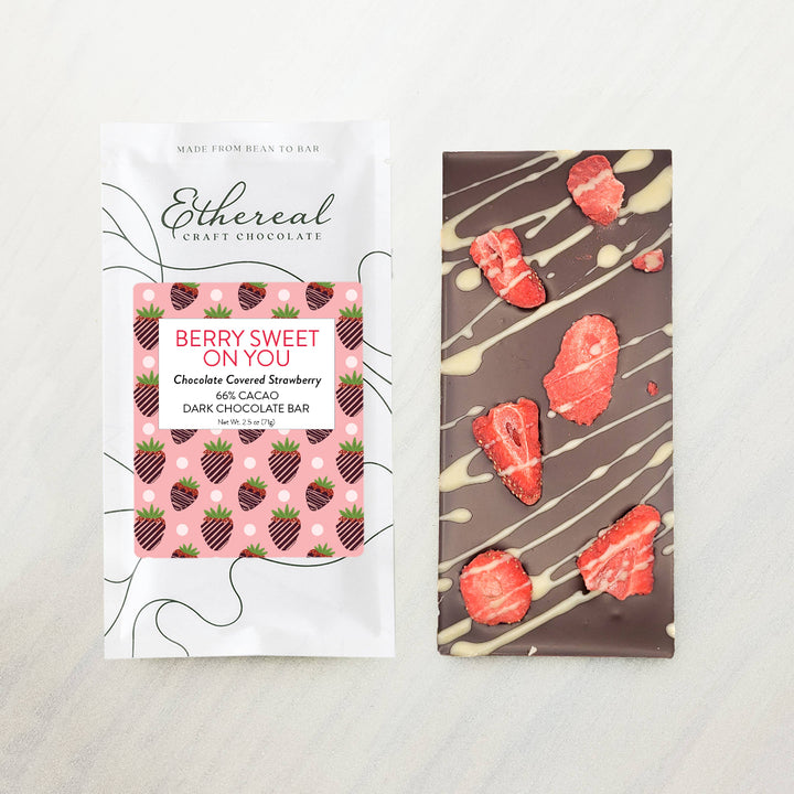 Dark chocolate bar with strawberry pieces and packaging labeled 'Ethereal Craft Chocolate' on a light background.