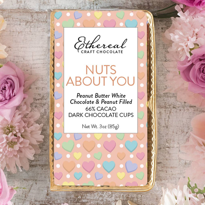 Ethereal Craft Chocolate packaging with heart designs on a wooden surface surrounded by flowers