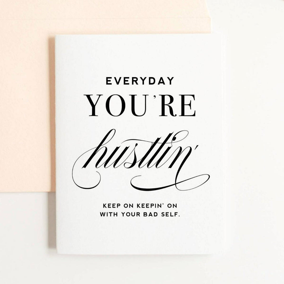 A simple white card with black text that reads "Everyday you're hustlin', keep on keepin' on with your bad self."