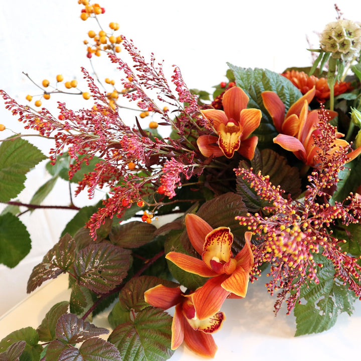 Autumn Centerpiece | A close up on the textured red/yellow florals and greenery.