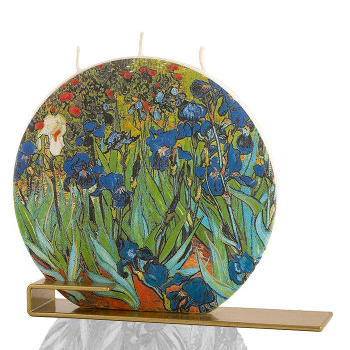 Standing candle with a floral design on a stand against a white background