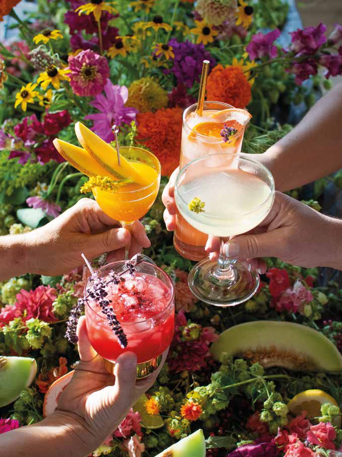 National Book Network | Flower-Infused Cocktail: Flowers, with a Twist | Hands holding different cocktails against a floral background.