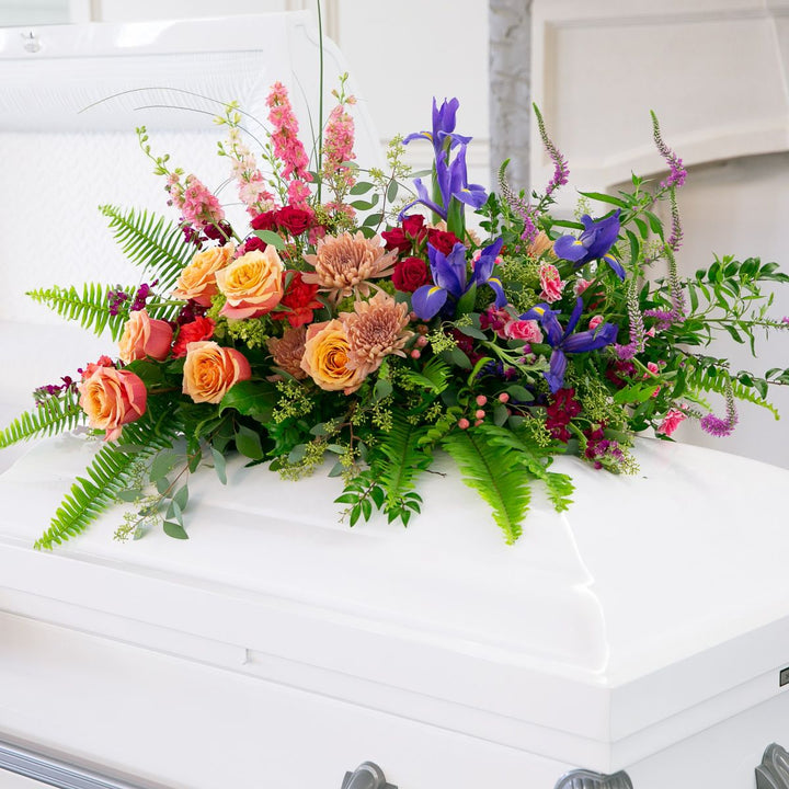 Colorful floral arrangement on a white casket