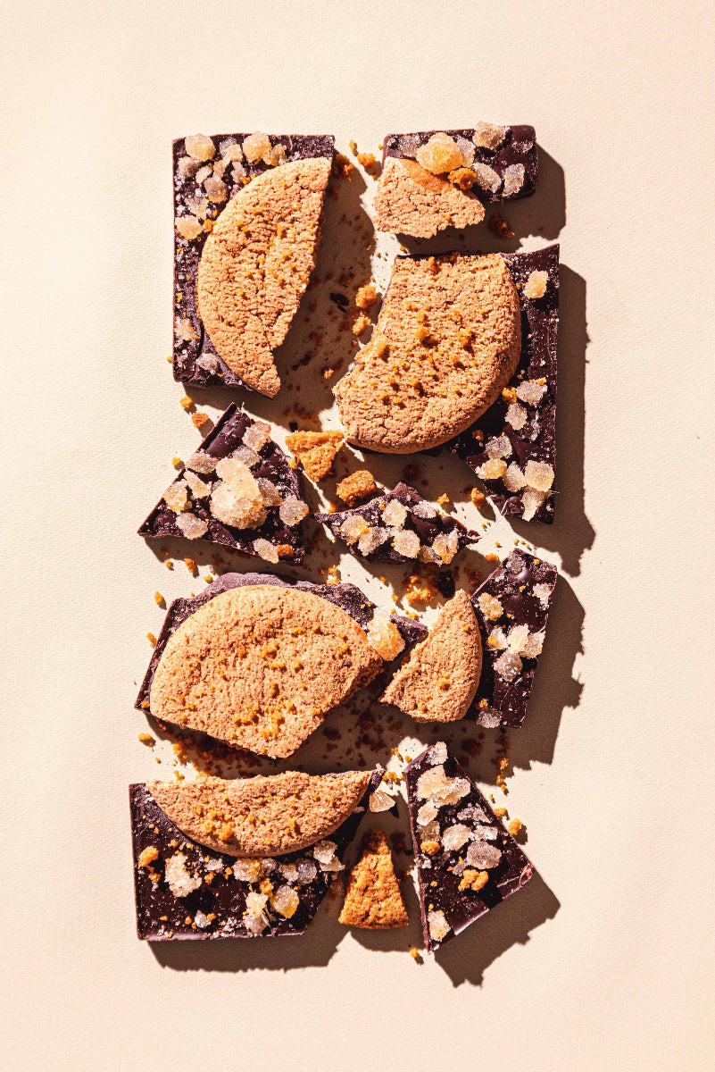 Chocolate bars with cookie pieces on a light pink background