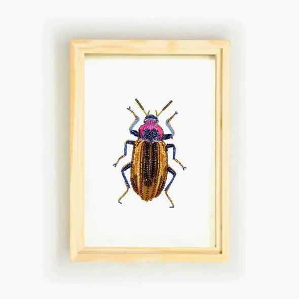 Trovelore | Eucyrtus Glorious Beetle Beaded wall art. A blue, purple, pink, and gold, beetle. Framed with a raw woodedn frame.