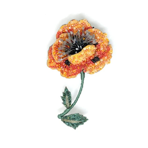 Decorative flower brooch with orange and red petals on a white background