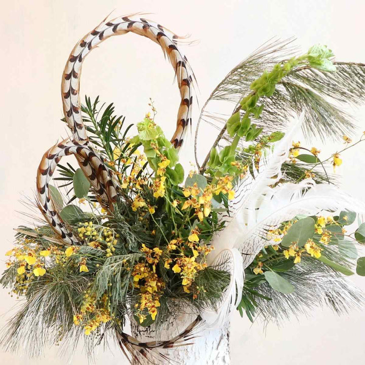 Stacy K Floral | Golden Woodland Arrangement | Orchids, feathers, and greenery in a white birch vase.