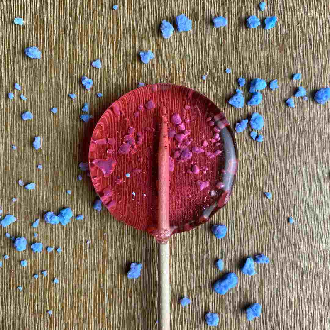 Good Lolli | Cotton Candy | A pink lollipop with blue cotton candy pieces.