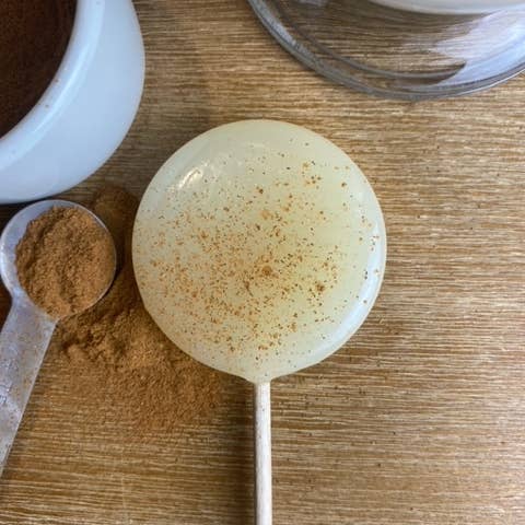 Good Lolli | Eggnog Lollipop | A creamy white lollipop with a dust of cinnamon.