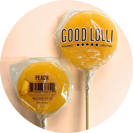 Good Lolli | Peach Lollipop | A yellow colored lollipop with a piece of peach on the interior.