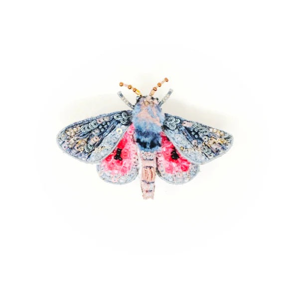 Decorative moth brooch with floral patterns on a white background