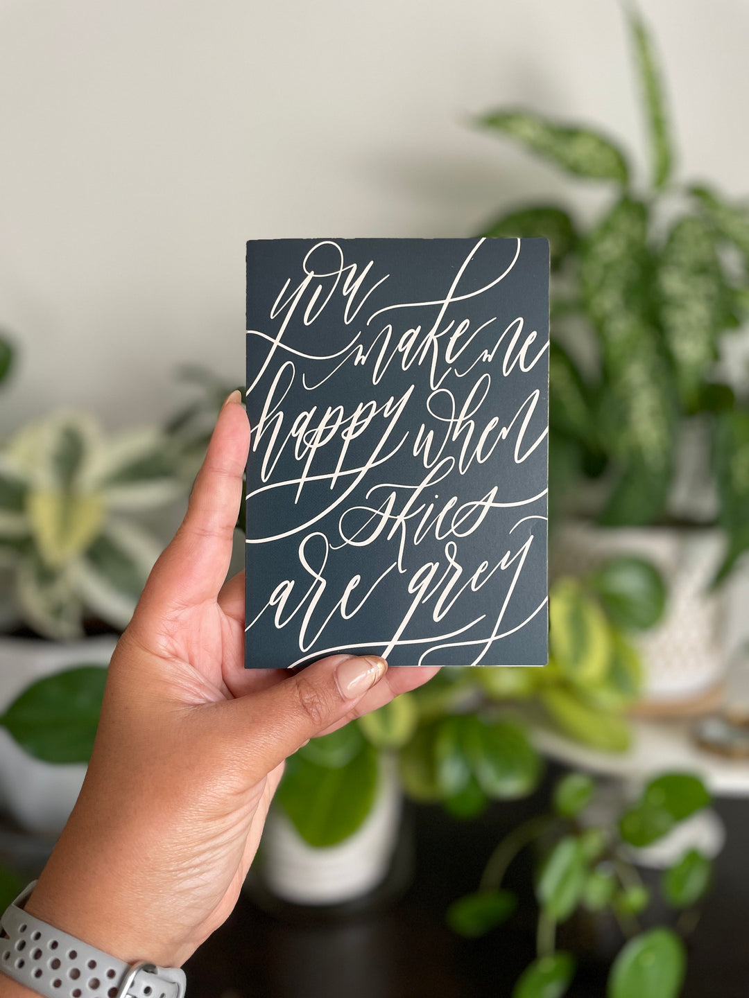 Elevate your heartfelt messages with our exquisite greeting card, where the phrase "You make me happy when skies are grey" is beautifully rendered in modern calligraphy, creating an artful expression of warmth and joy.