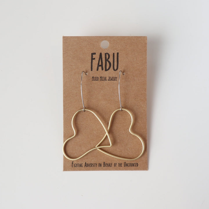 Fabu Earrings | Gold earrings shaped like a heart.  On a brown paper backing. Reads "Fabu, mixed metal jewelry, Fighting Adversity on Behalf of the Uncounted".