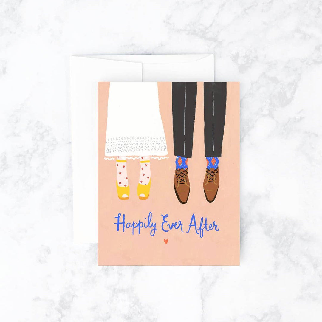 Idlewild Co. | Bride & Groom Card | A peach card with illustrated bride and groom's legs and text that reads "Happily Ever After".