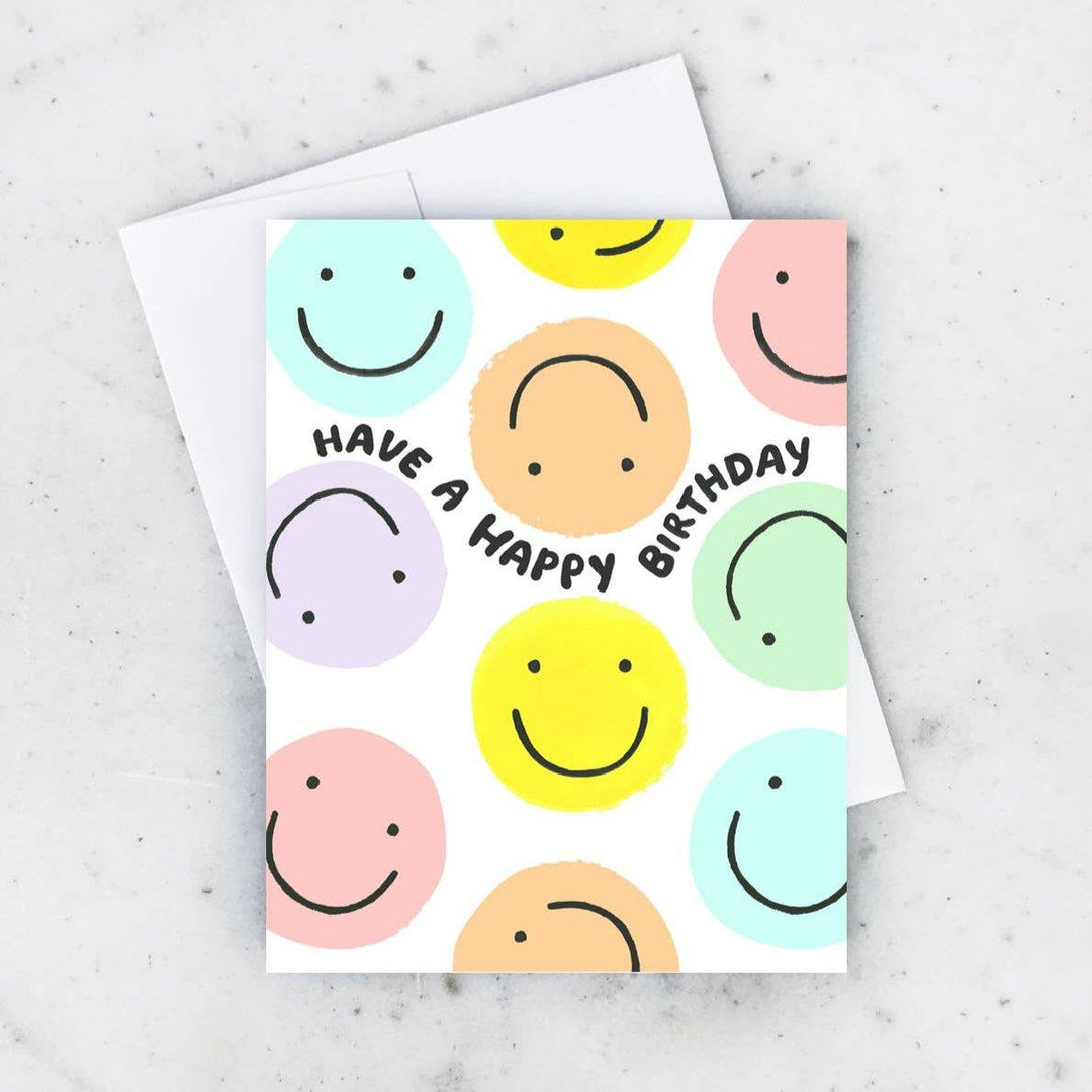 Idlewild Co. | Smiley Birthday Card | Card full of colorful smiley faces and text that reads "Have a happy birthday".