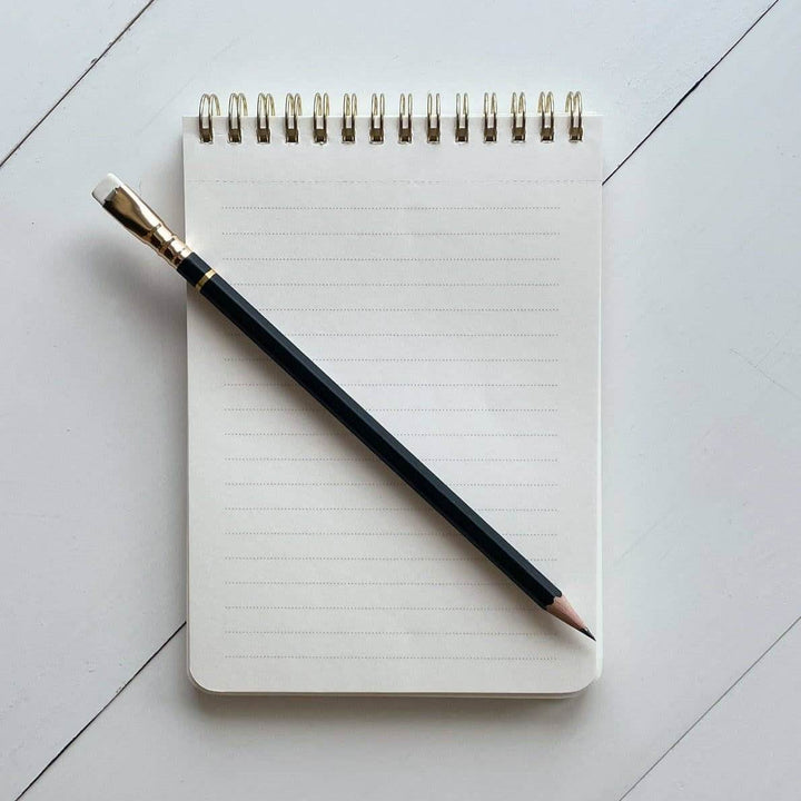 Idlewild Co. | Checked Notepad | Lined interior sheets with a spiral bound top. Black pencil displayed on top.