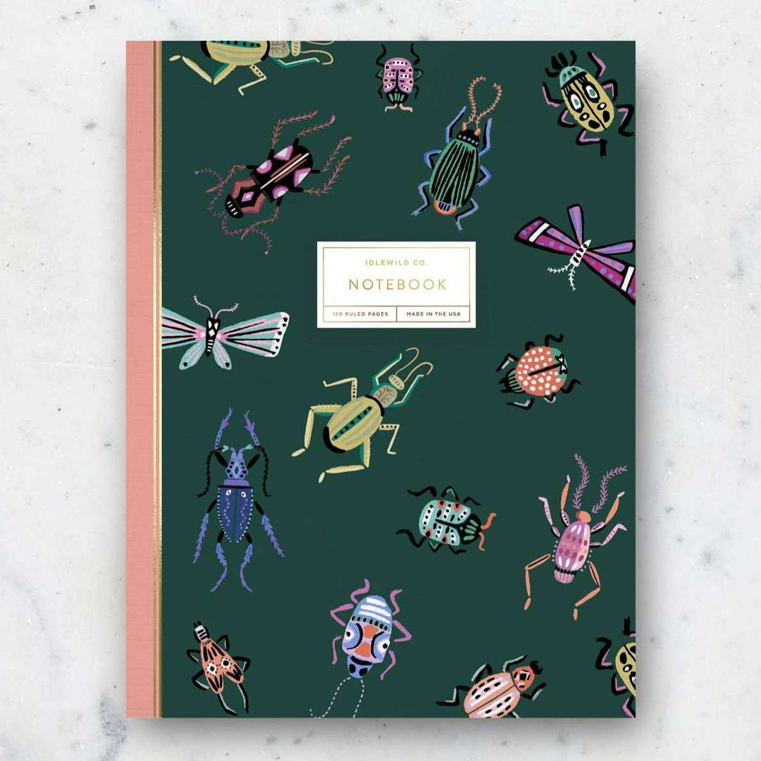 Idlewild Co. | Entomologist Notebook | A green notebook with a green background covered in illustrated bugs such as beetles, and moths.