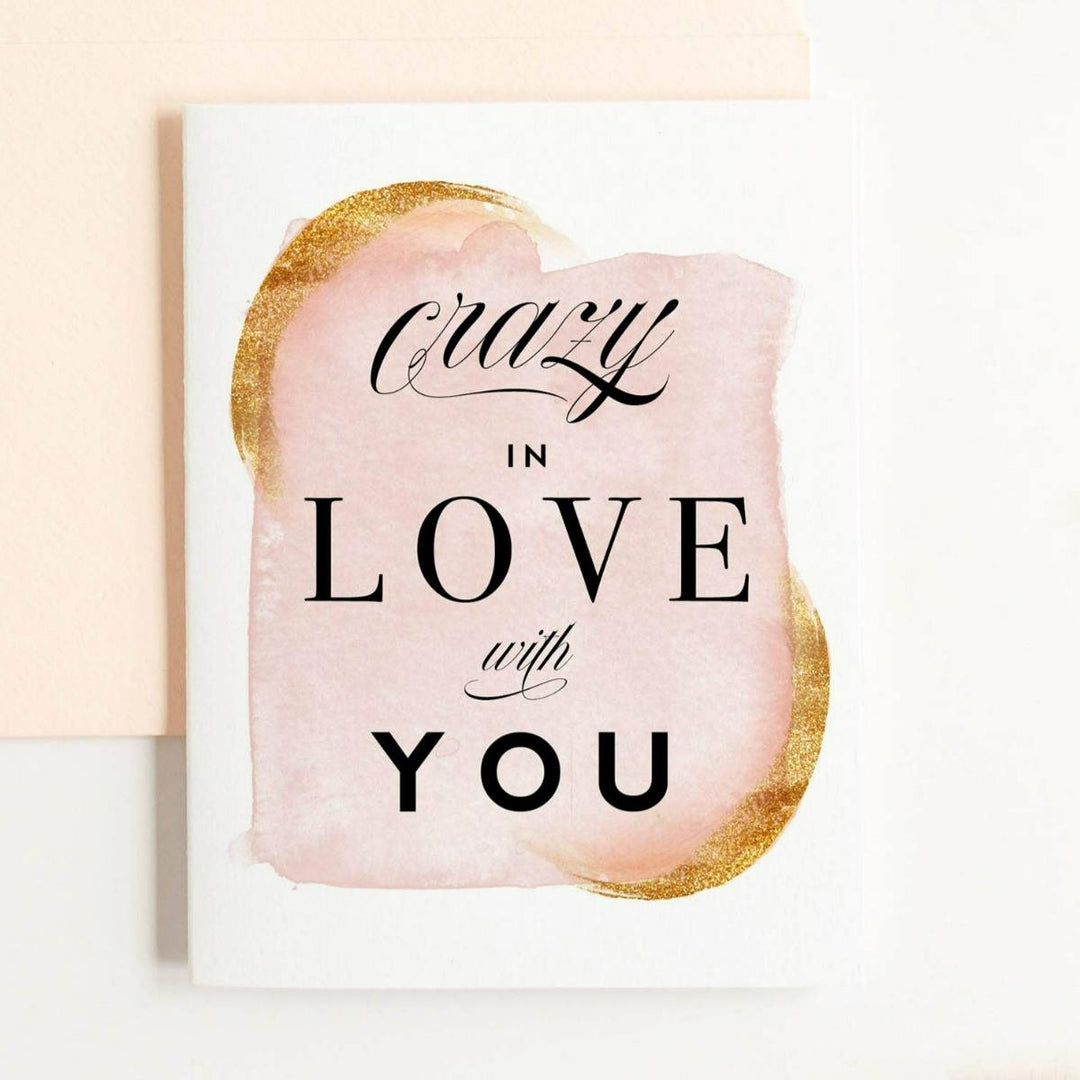 A pink and gold watercolor patterned card with black text that reads "Crazy in love with you".