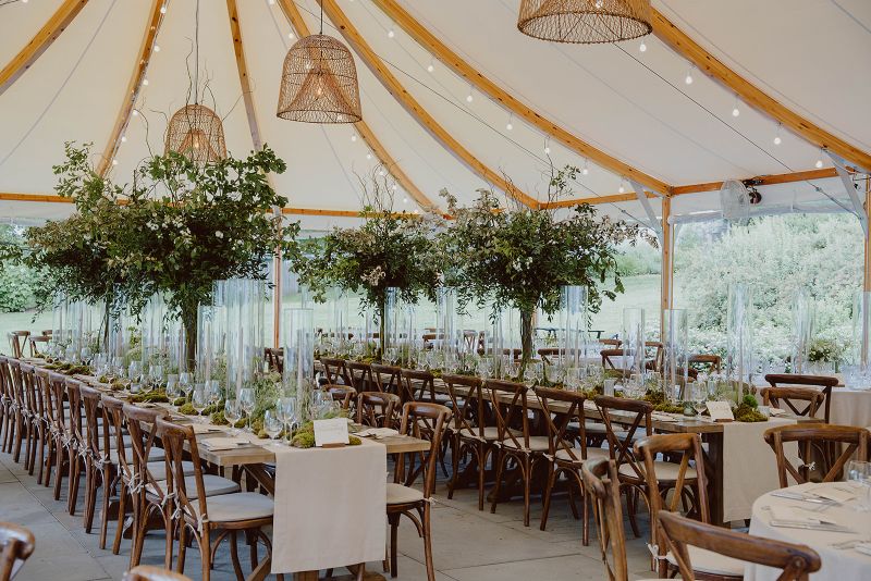 Inns of Aurora | Stacy K Floral | Reception tent photo with tables lined with mini trees, moss, grasses, and taper candles.