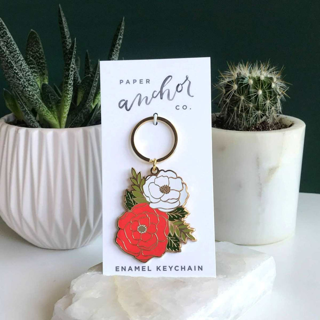 Paper Anchor Co. | Irene Floral Keychain | Photo of the keychain with its simple white backing. Photo taken against a background with a succulent and cactus.