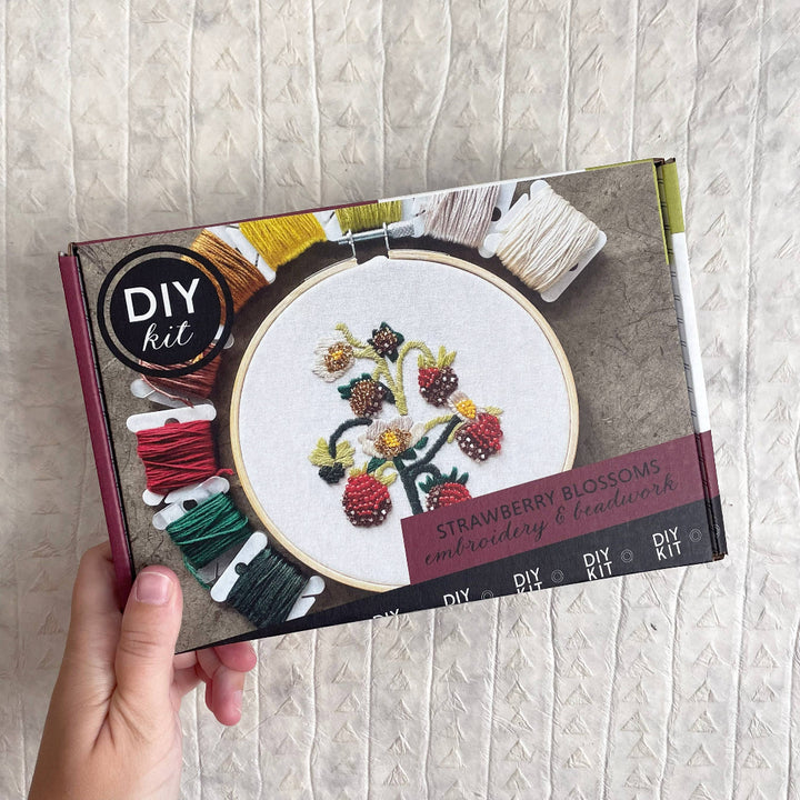 DIY embroidery kit with strawberry blossoms design on a textured surface