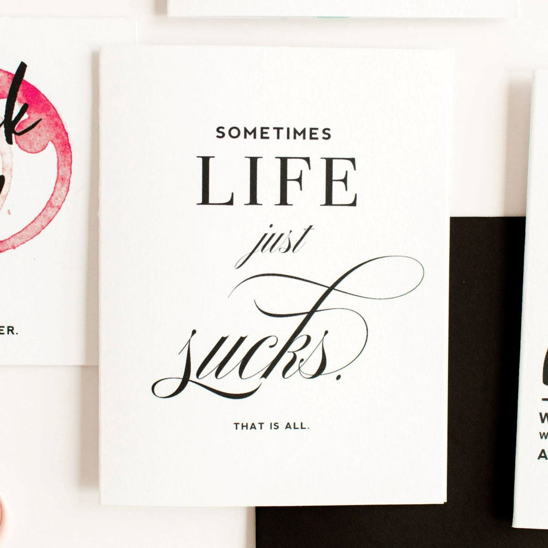 A simple white card with black text that reads "Sometimes life just sucks. That is all.".