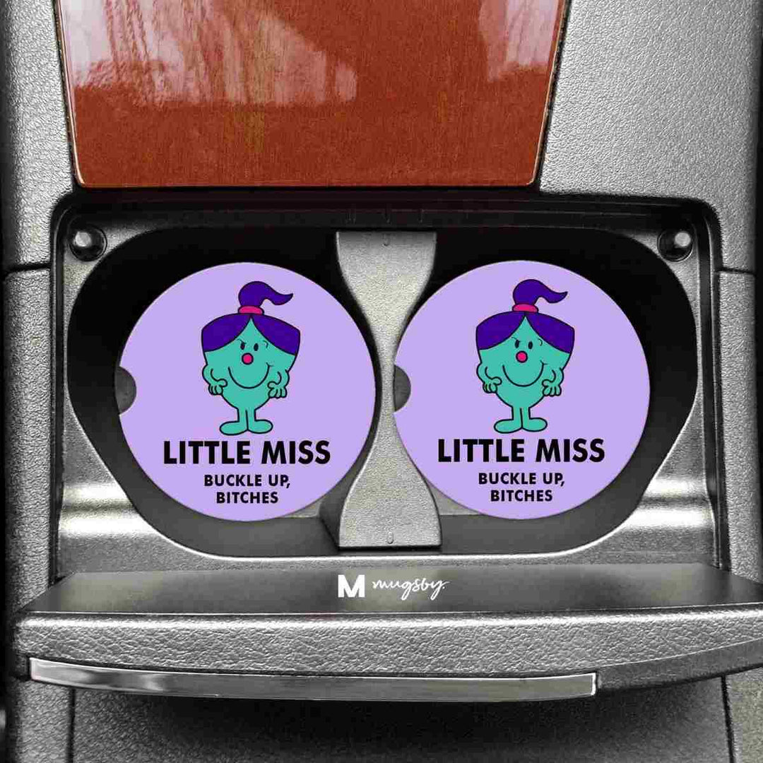 Little Miss Buckles Up Bitches Funny Car Coasters | A light purple coaster with a cartoon character that reads "Little Miss Buckle up, bitches"