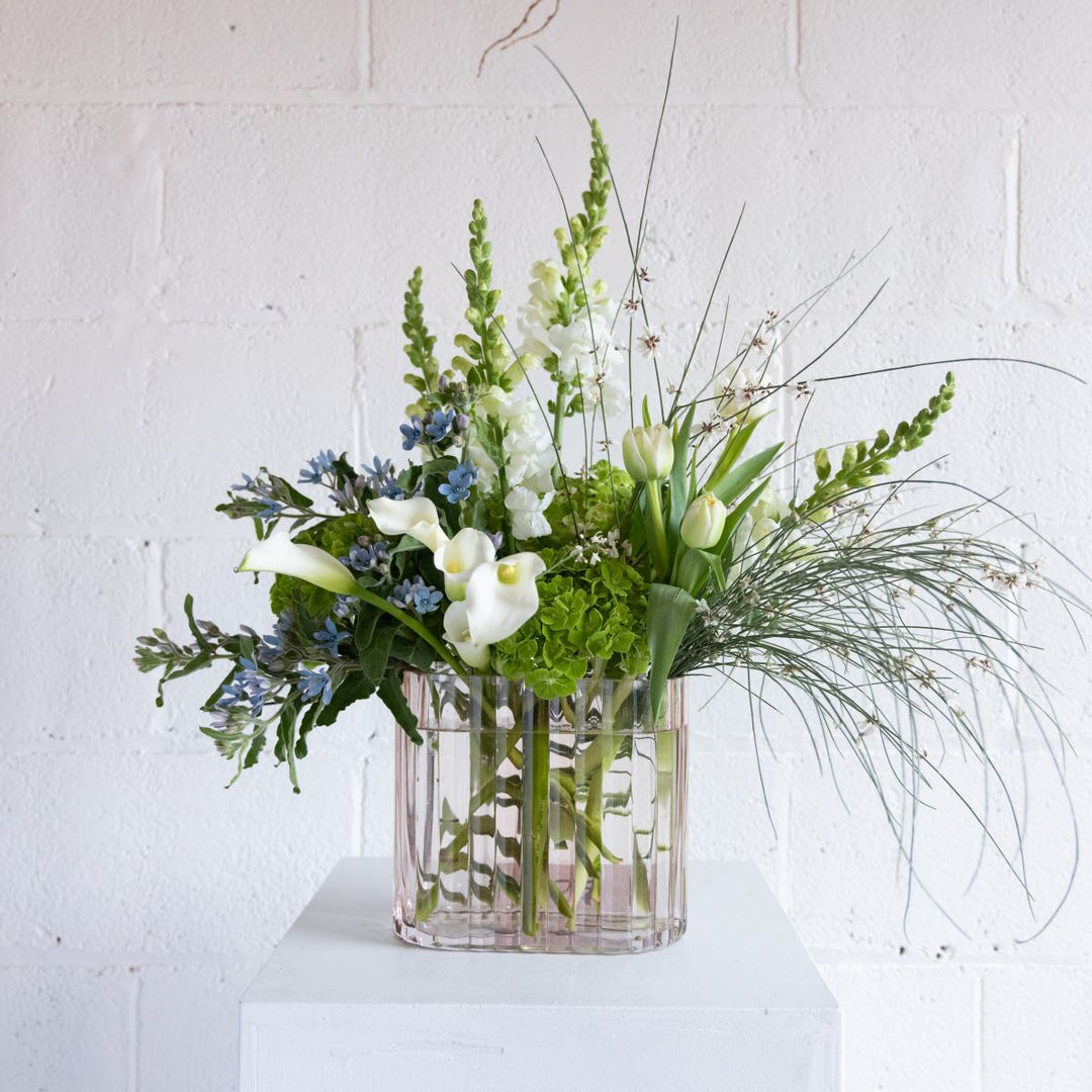 a green, white and blue fresh floral arrangement.